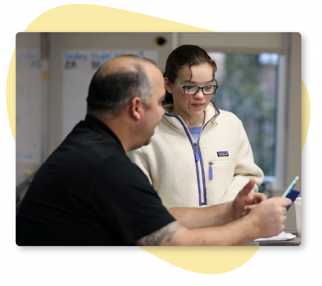 A Science of Reading teacher providing feedback to his student on an assignment.